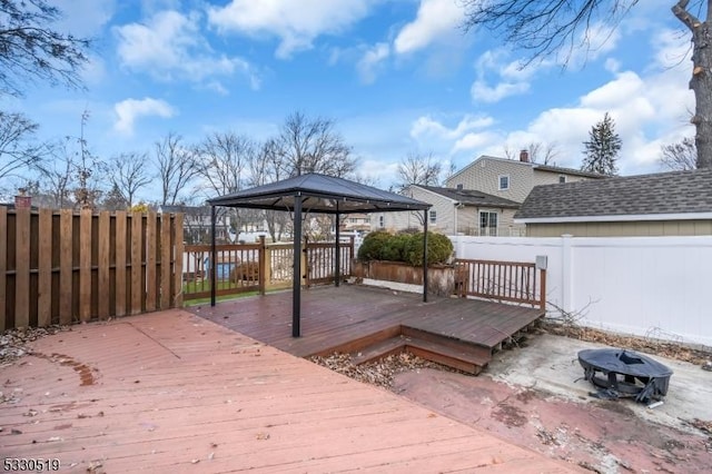 deck featuring a gazebo and a fire pit