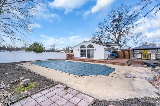 view of pool with a gazebo, a patio, a deck, and an outbuilding