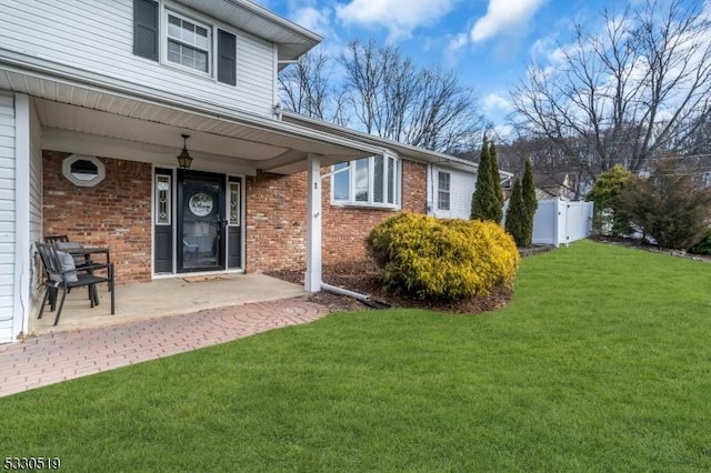 property entrance with a yard and a patio area