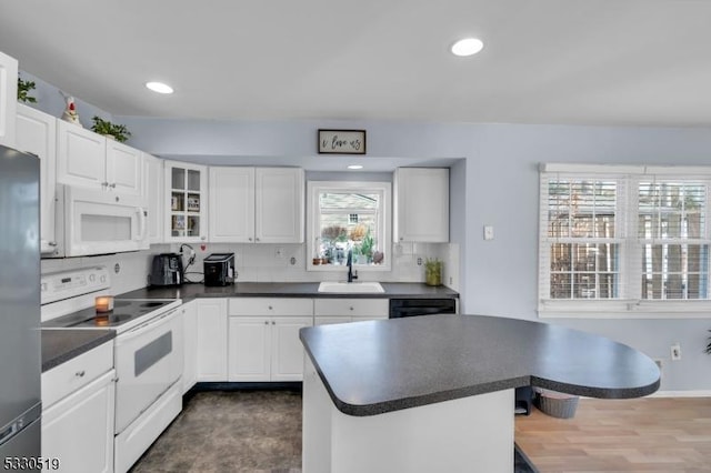 kitchen with sink, white appliances, white cabinetry, and tasteful backsplash