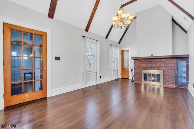 unfurnished living room featuring a brick fireplace, lofted ceiling with beams, an inviting chandelier, and dark hardwood / wood-style flooring