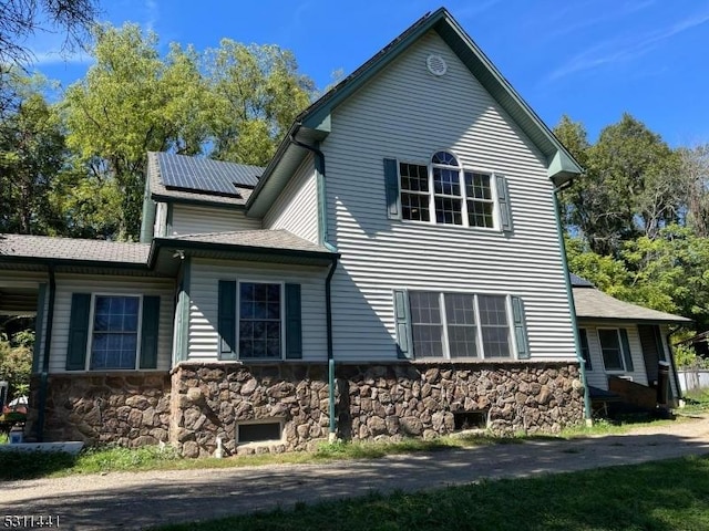 view of side of property with solar panels