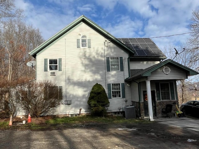 view of property exterior featuring solar panels and central AC