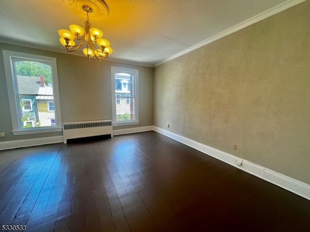 empty room featuring dark wood-type flooring, an inviting chandelier, radiator, and ornamental molding