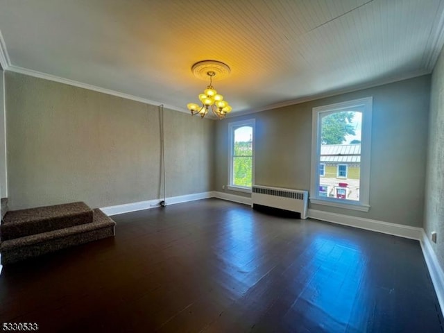 unfurnished room featuring plenty of natural light, radiator heating unit, ornamental molding, and an inviting chandelier