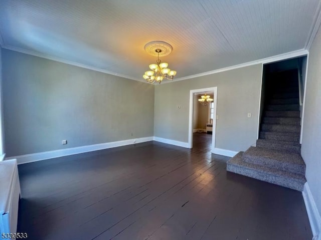 empty room featuring dark hardwood / wood-style floors, crown molding, and an inviting chandelier