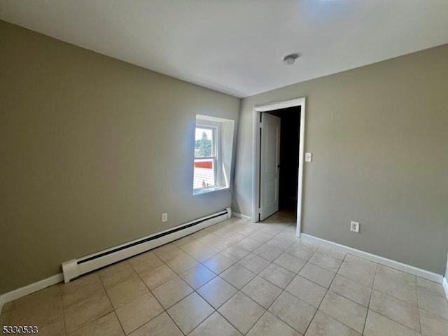 tiled spare room featuring baseboard heating