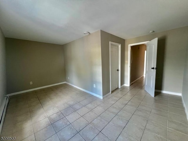 spare room featuring baseboard heating and light tile patterned flooring