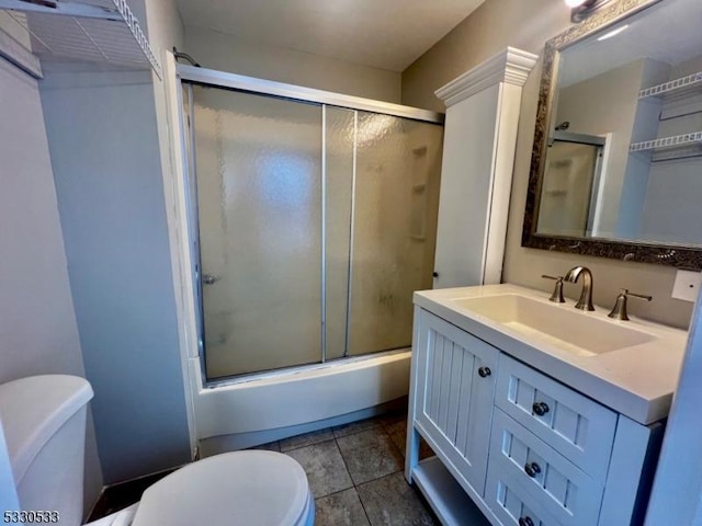 full bathroom with tile patterned flooring, vanity, toilet, and bath / shower combo with glass door