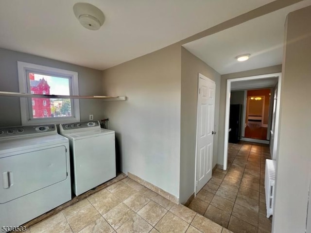 clothes washing area featuring radiator heating unit and washing machine and clothes dryer