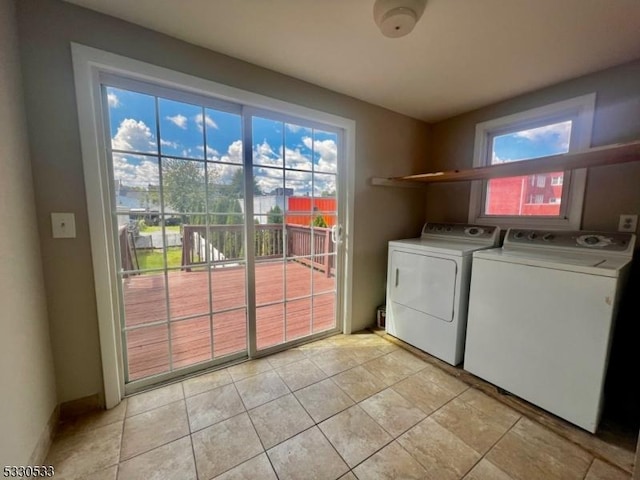 washroom with washing machine and clothes dryer and light tile patterned floors