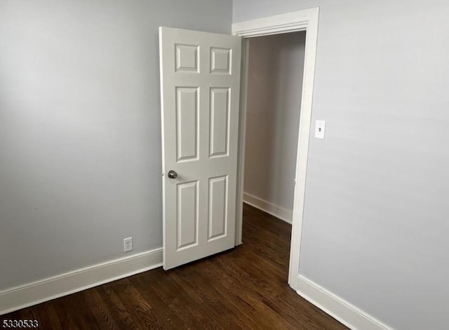 empty room with dark hardwood / wood-style flooring