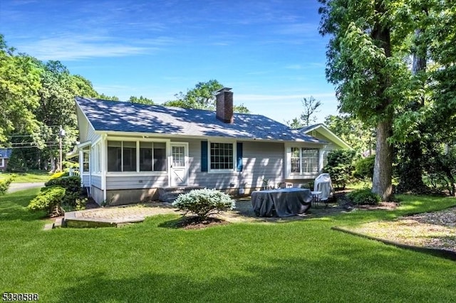 back of house with a sunroom and a yard