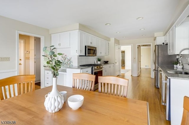 dining area featuring sink and light hardwood / wood-style flooring