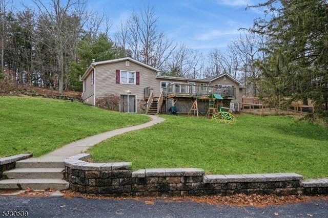 back of property featuring a lawn and a wooden deck