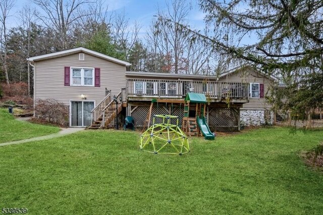 back of property featuring a lawn and a wooden deck