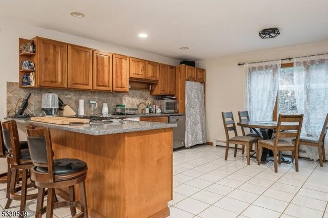 kitchen with stainless steel dishwasher, decorative backsplash, light tile patterned floors, stone countertops, and kitchen peninsula