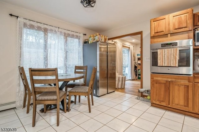 dining area with light tile patterned flooring and a baseboard heating unit