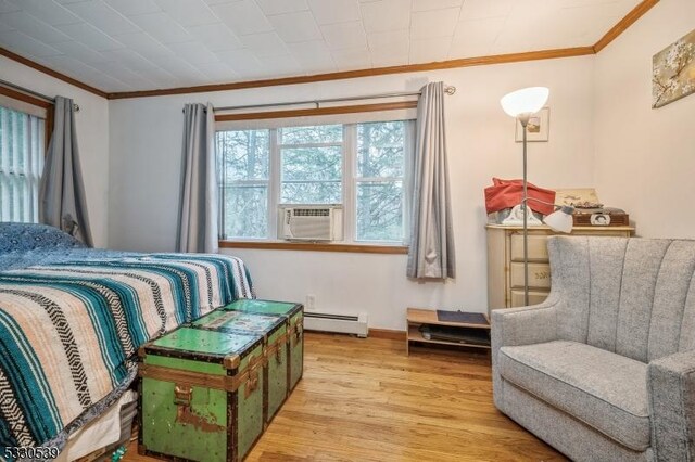 bedroom with crown molding, cooling unit, a baseboard radiator, and light wood-type flooring