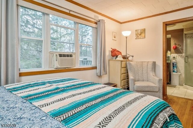 bedroom with wood-type flooring, cooling unit, and ornamental molding