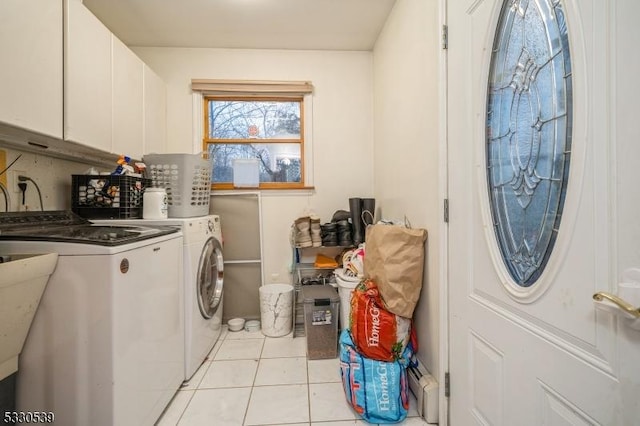 clothes washing area with light tile patterned flooring, cabinets, and independent washer and dryer