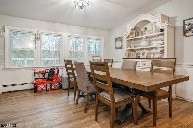 dining space with light hardwood / wood-style flooring and a baseboard heating unit