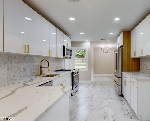 kitchen with white cabinets, light stone counters, sink, and appliances with stainless steel finishes