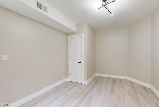 unfurnished room with light hardwood / wood-style floors and an inviting chandelier