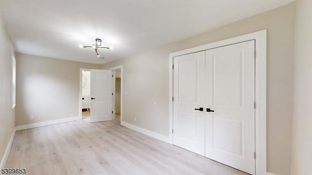 unfurnished bedroom with light hardwood / wood-style floors and a closet