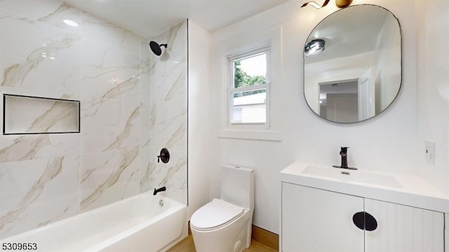 full bathroom with vanity, tiled shower / bath combo, and toilet