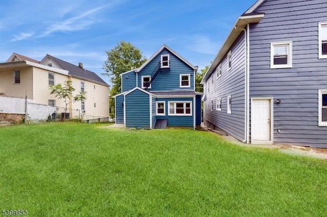 rear view of house featuring a lawn