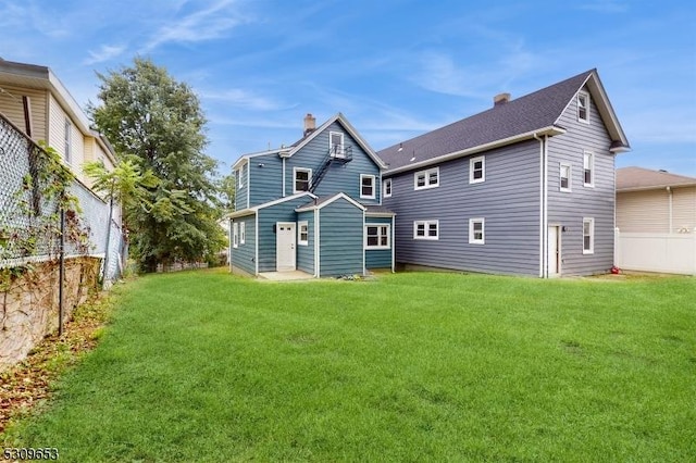 rear view of property with a yard