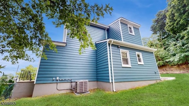 view of side of home with a lawn and cooling unit