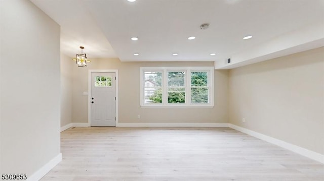 foyer featuring light hardwood / wood-style flooring and an inviting chandelier