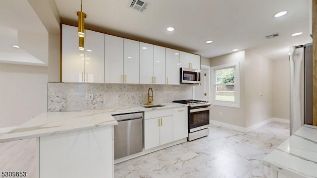 kitchen featuring decorative backsplash, kitchen peninsula, stainless steel appliances, sink, and white cabinets