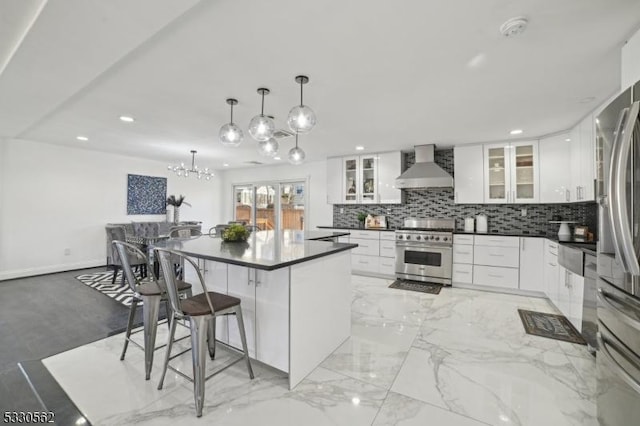 kitchen with backsplash, wall chimney exhaust hood, dark countertops, and stainless steel stove