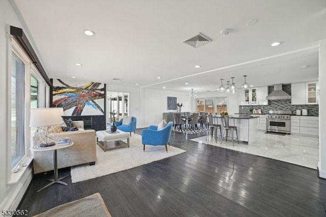 living area with recessed lighting, visible vents, and wood finished floors