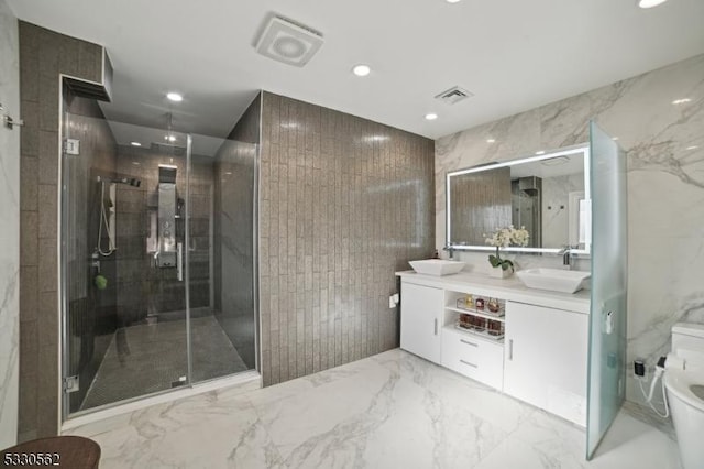 full bathroom with visible vents, marble finish floor, a stall shower, a sink, and tile walls