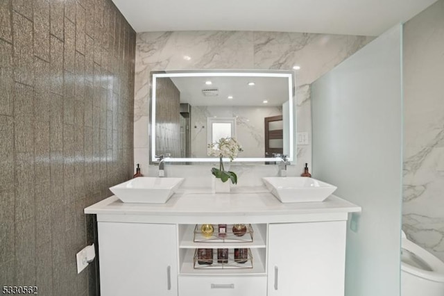 bathroom with double vanity, recessed lighting, a shower, and a sink