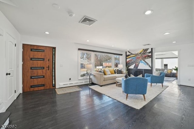 living area featuring recessed lighting, visible vents, baseboard heating, and wood finished floors