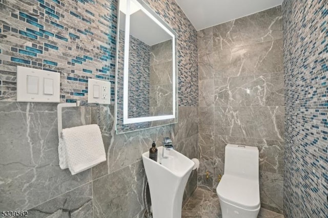 bathroom with tile walls and toilet