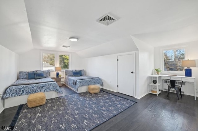 bedroom with visible vents, lofted ceiling, baseboards, and wood finished floors