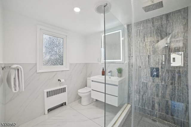 full bath with a tile shower, toilet, radiator, and vanity