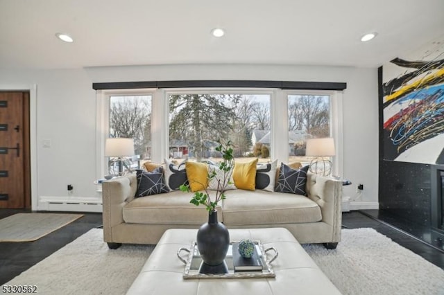 living room featuring recessed lighting, a baseboard heating unit, and wood finished floors