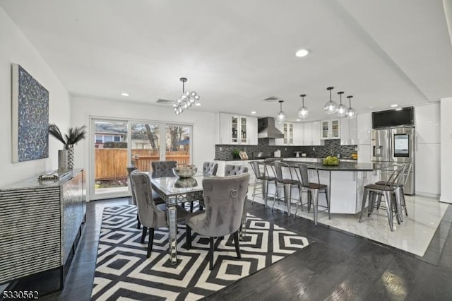 dining room with a chandelier, recessed lighting, and wood finished floors