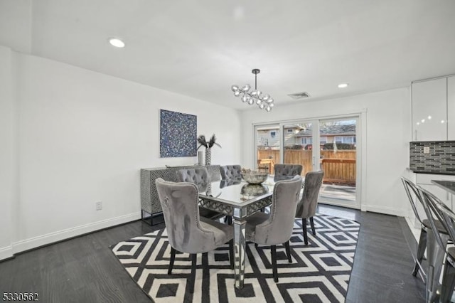 dining space with recessed lighting, baseboards, dark wood-type flooring, and an inviting chandelier