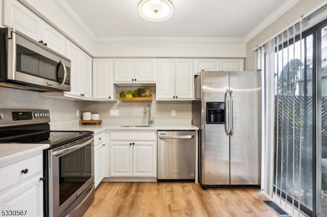 kitchen featuring crown molding, sink, white cabinets, and stainless steel appliances