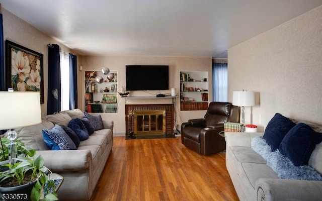 living room with hardwood / wood-style flooring and a brick fireplace