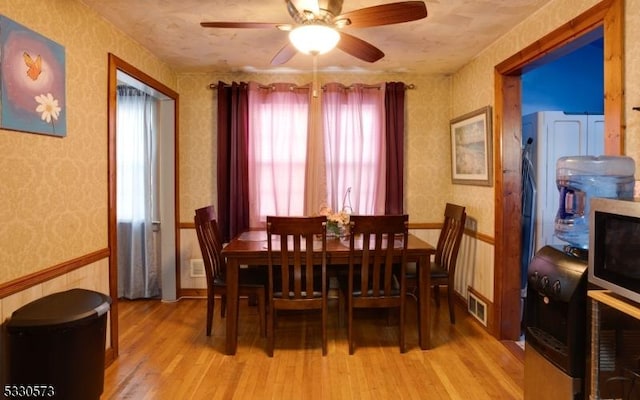 dining area with light hardwood / wood-style flooring and ceiling fan