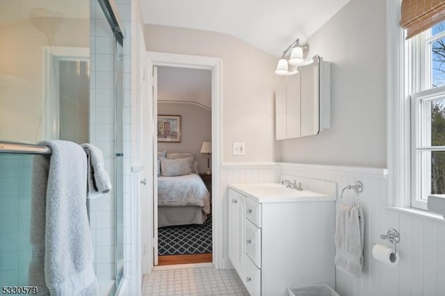 bathroom featuring vanity, a shower with door, and vaulted ceiling